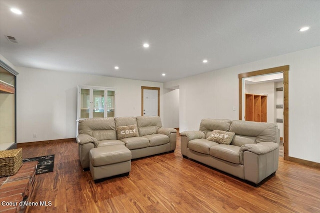 living area with recessed lighting, baseboards, wood finished floors, and visible vents