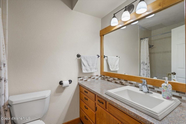 full bath with vanity, tasteful backsplash, toilet, and tiled shower