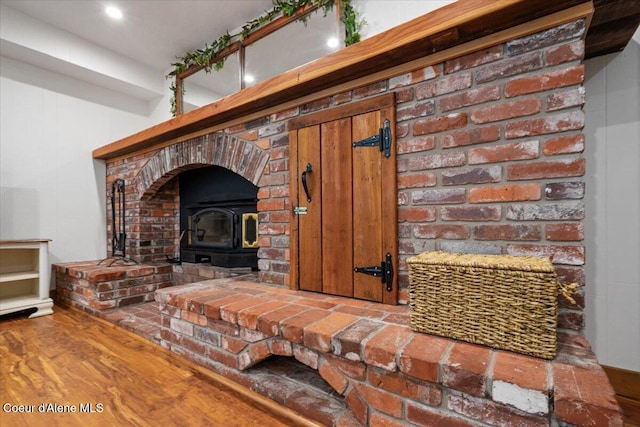 interior details with a wood stove and wood finished floors