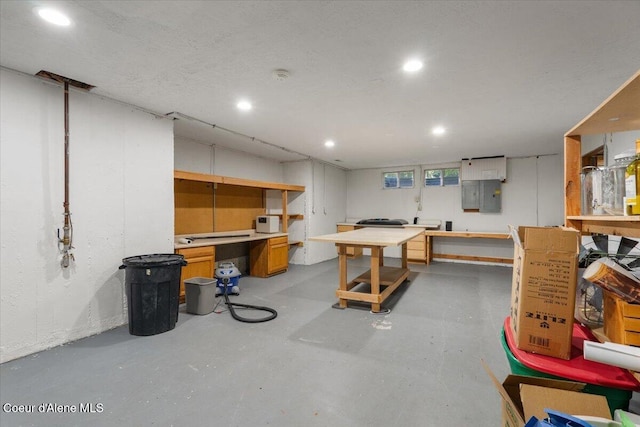below grade area featuring a workshop area, electric panel, and recessed lighting