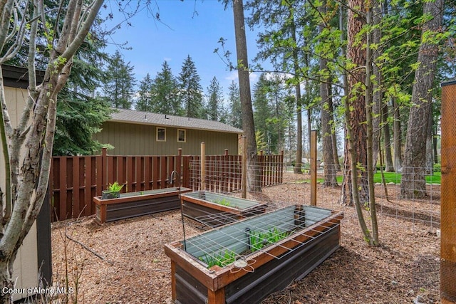 view of yard with fence and a vegetable garden