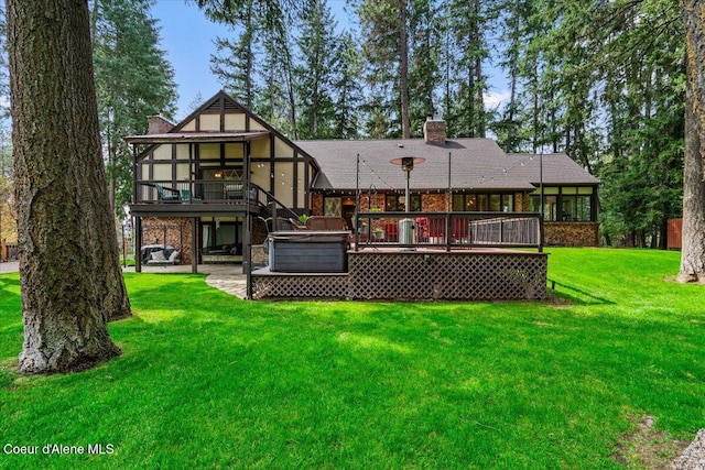 back of property with a covered hot tub, a wooden deck, a sunroom, a patio, and a yard