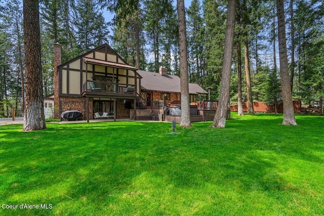 rear view of property with stairs, a lawn, a wooden deck, and a chimney