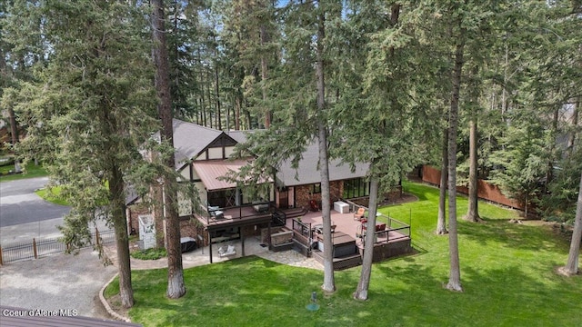 rear view of property with a lawn, fence, and a wooden deck
