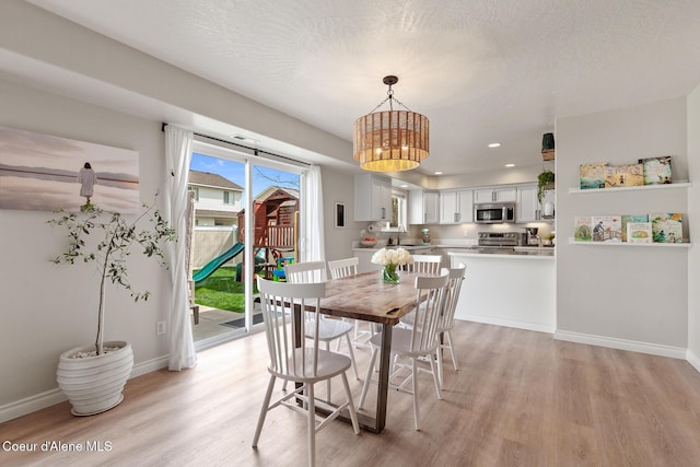dining room featuring light wood-style floors, recessed lighting, a notable chandelier, and baseboards