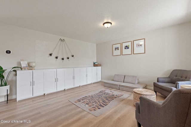 living area featuring light wood-type flooring and baseboards
