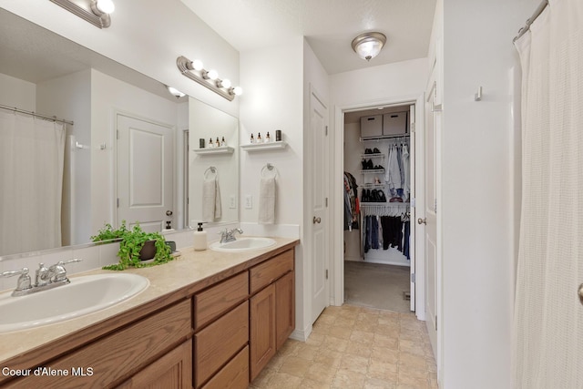 bathroom featuring curtained shower, double vanity, a sink, and a spacious closet