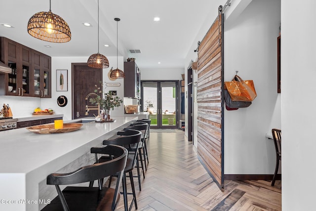 kitchen featuring a kitchen breakfast bar, a barn door, recessed lighting, and a sink
