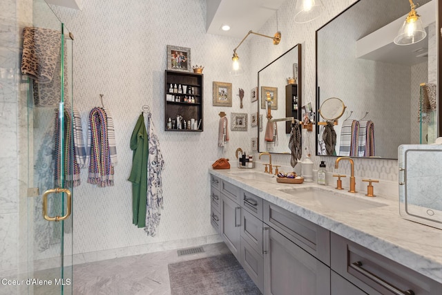 bathroom featuring double vanity, visible vents, a shower stall, and a sink