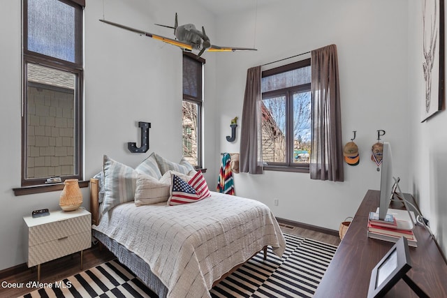 bedroom featuring baseboards and wood finished floors