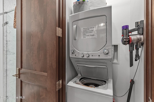 washroom with stacked washing maching and dryer and laundry area