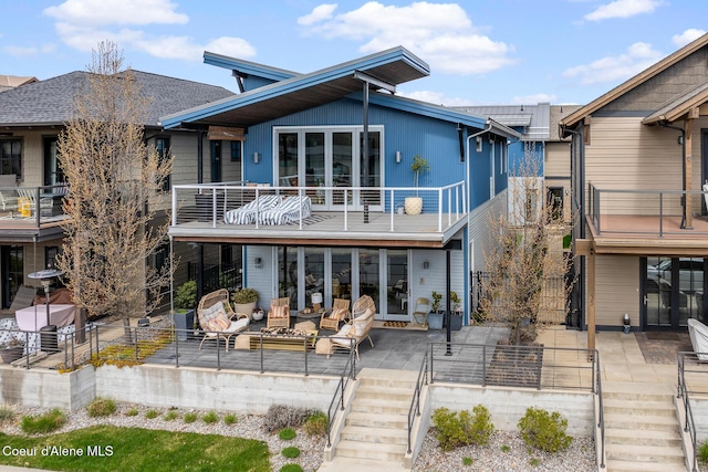 rear view of house featuring an outdoor living space, stairs, and a balcony