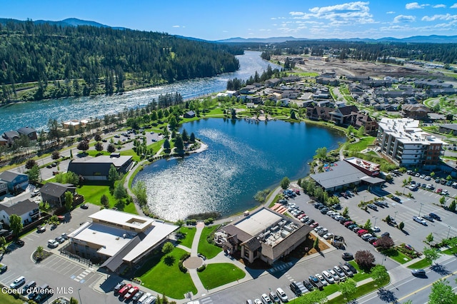 aerial view with a water and mountain view and a forest view