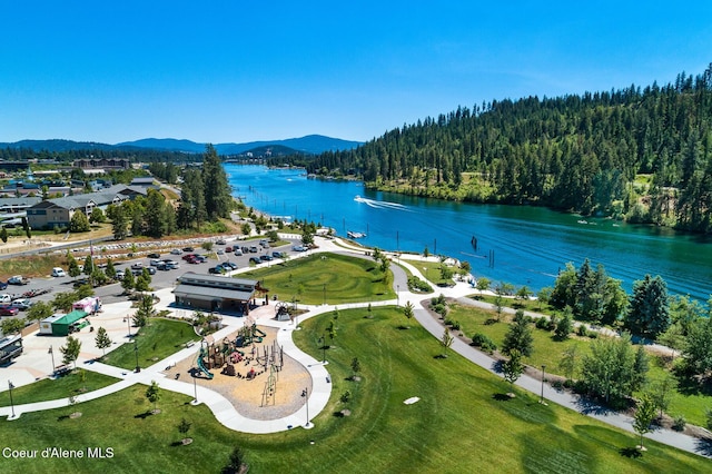 drone / aerial view featuring a water and mountain view and a forest view