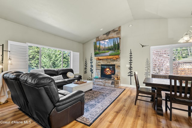 living area with high vaulted ceiling, a fireplace, and wood finished floors