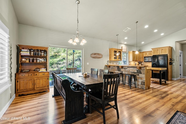 dining room with light wood-style floors, lofted ceiling, recessed lighting, and a notable chandelier