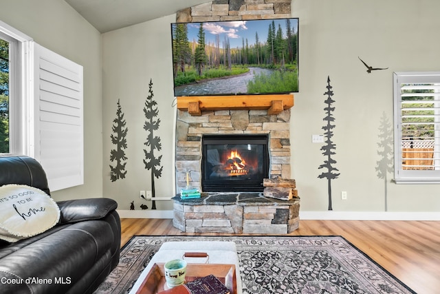 living room with baseboards, a fireplace, wood finished floors, and lofted ceiling