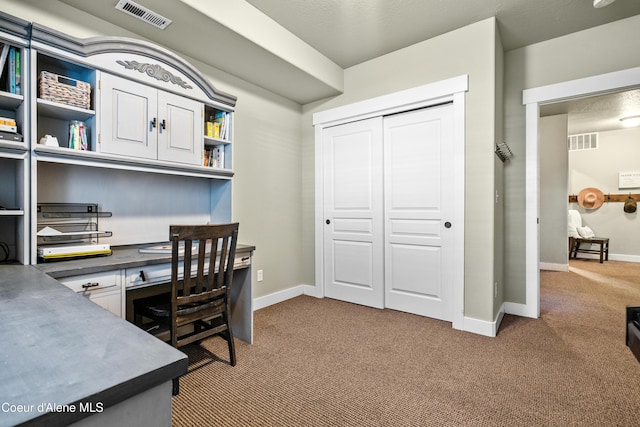 office featuring baseboards, visible vents, and carpet