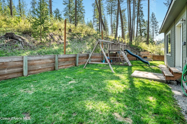 view of yard with a playground and a fenced backyard