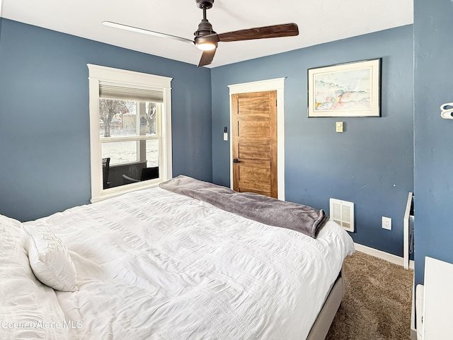 bedroom with dark colored carpet, visible vents, a ceiling fan, and baseboards