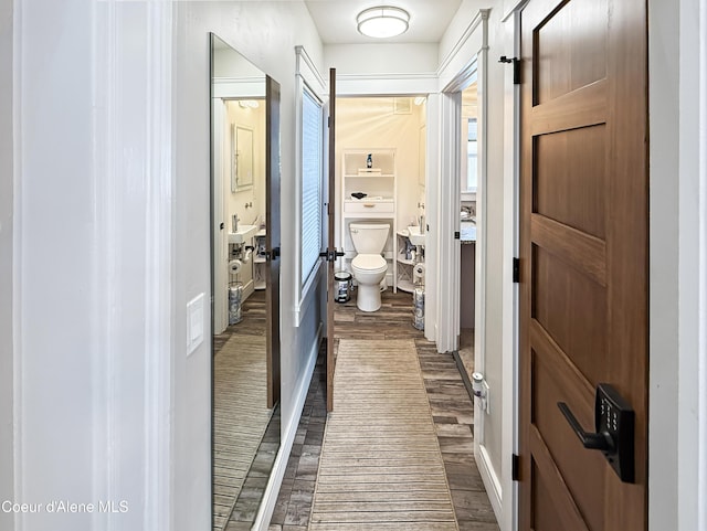 bathroom with wood finished floors, toilet, and baseboards