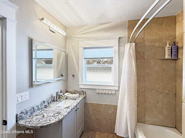 bathroom featuring shower / bath combination with curtain, a wealth of natural light, and vanity