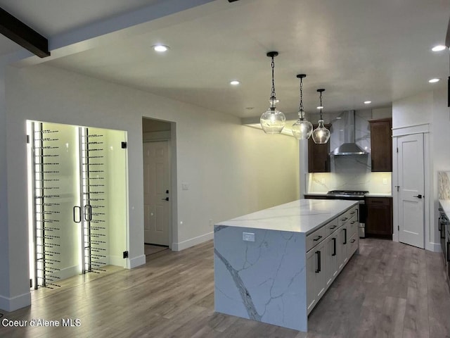 1373 N Gabrio Ct, Post Falls, ID 83854 - kitchen with stainless steel range, a center island, recessed lighting, wall chimney exhaust hood, and wood finished floors