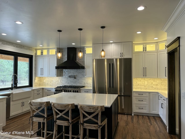 1373 N Gabrio Ct, Post Falls, ID 83854 - kitchen featuring wall chimney exhaust hood, a sink, stainless steel appliances, and dark wood-type flooring