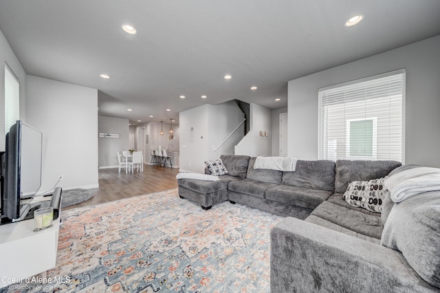 living area featuring stairway, plenty of natural light, recessed lighting, and wood finished floors