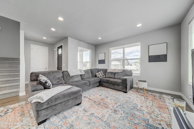 living room featuring recessed lighting, stairs, baseboards, and wood finished floors