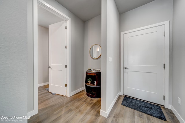 foyer entrance featuring baseboards and wood finished floors