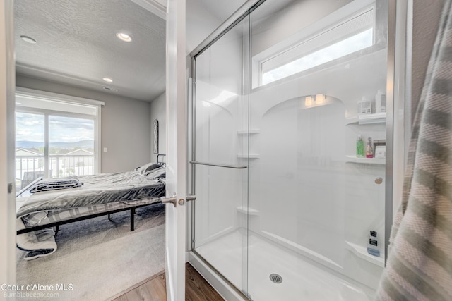 full bath with a textured ceiling, ensuite bath, a shower stall, wood finished floors, and recessed lighting