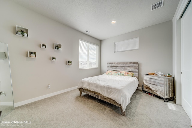 carpeted bedroom with baseboards and visible vents