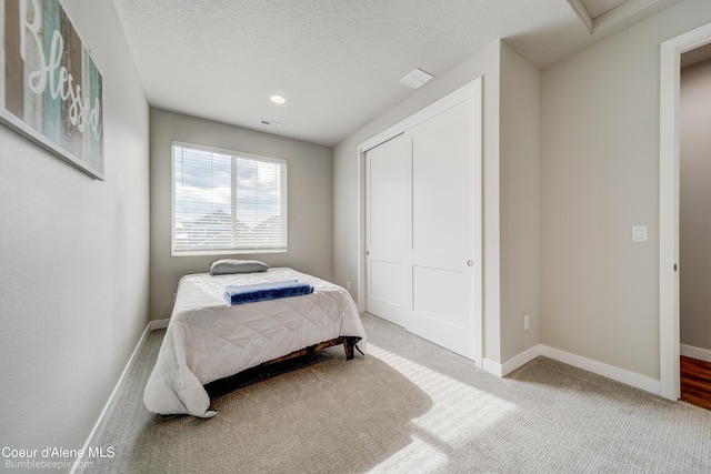 bedroom with baseboards, carpet, a closet, and visible vents