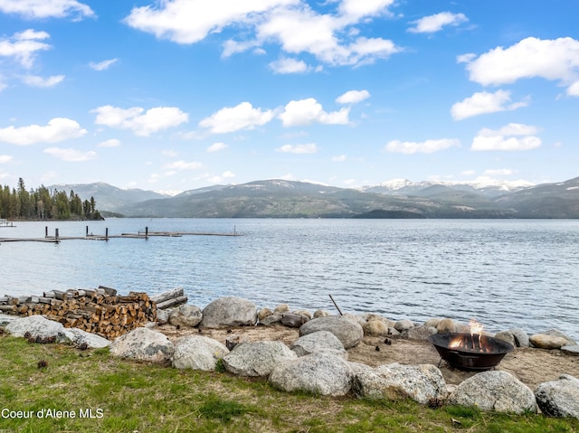 water view with a fire pit and a mountain view