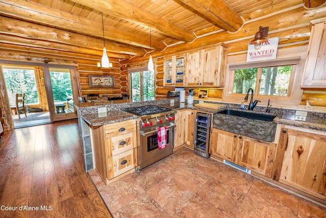 kitchen with a sink, beverage cooler, luxury range, and a healthy amount of sunlight