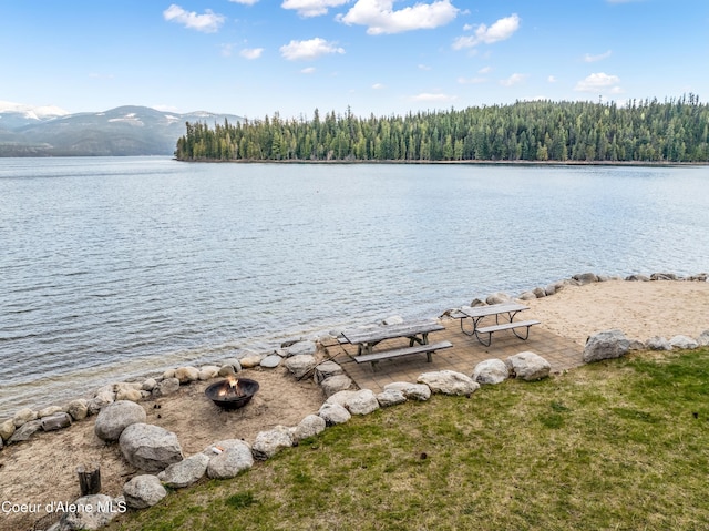water view featuring a forest view, a mountain view, and an outdoor fire pit