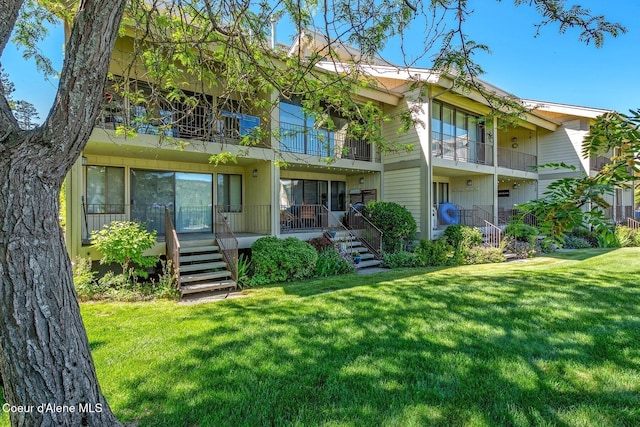 back of house with a yard, stairway, and a balcony