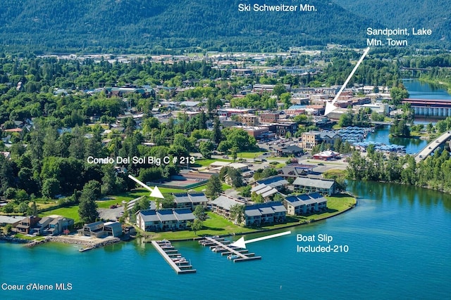 birds eye view of property featuring a water view and a wooded view