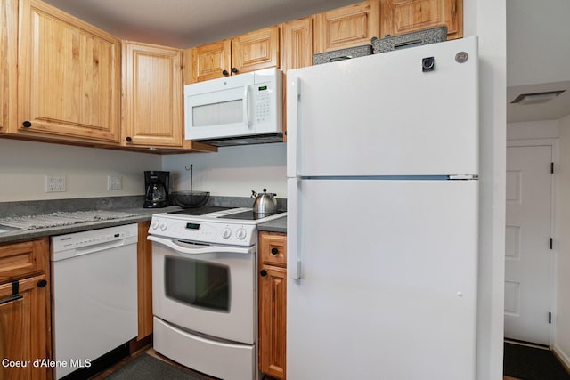 kitchen with visible vents, dark countertops, and white appliances