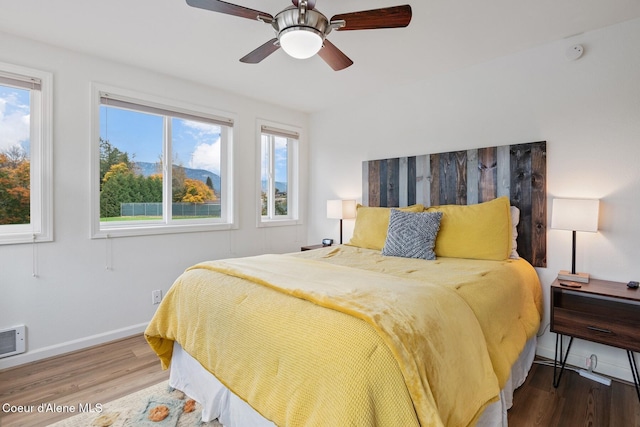 bedroom featuring baseboards, ceiling fan, and wood finished floors