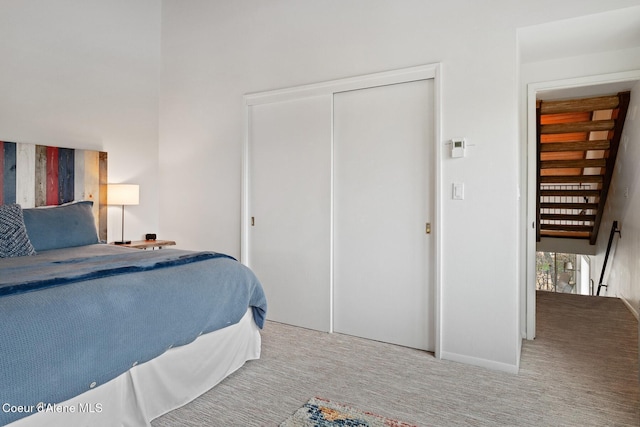 bedroom featuring a closet, baseboards, and carpet flooring