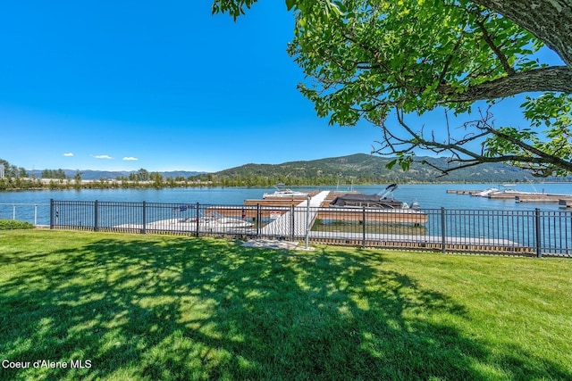 view of yard featuring fence and a water and mountain view