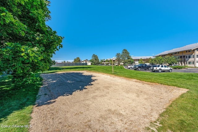 view of property's community featuring a lawn, a residential view, and uncovered parking