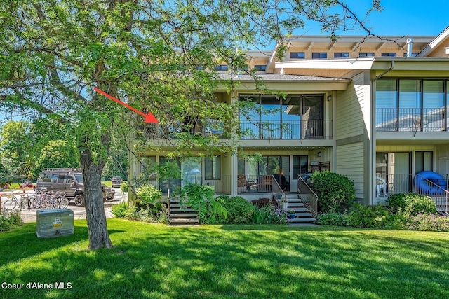 rear view of property featuring a yard and a porch