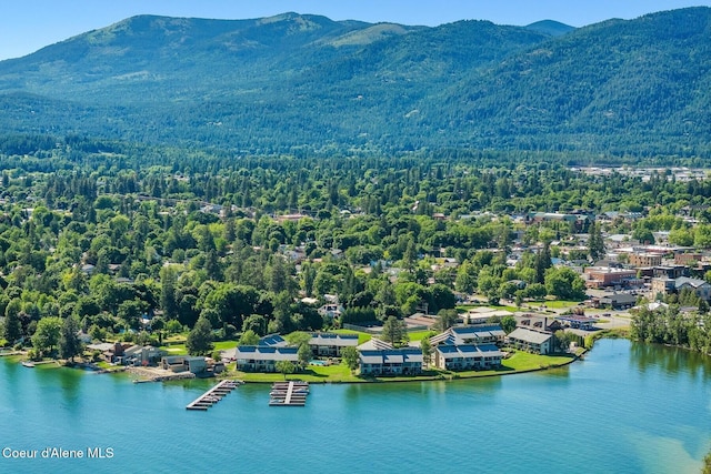 aerial view featuring a water and mountain view and a forest view