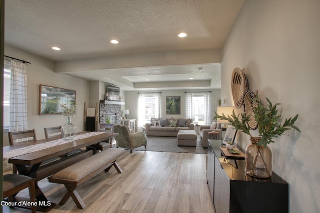 1733 N Minam Loop, Post Falls, ID 83854 - living area featuring a textured ceiling, a tray ceiling, light wood-style flooring, and recessed lighting