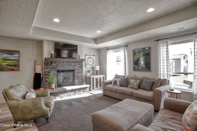 1733 N Minam Loop, Post Falls, ID 83854 - living room with visible vents, a healthy amount of sunlight, a textured ceiling, and a fireplace