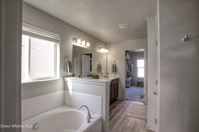 1733 N Minam Loop, Post Falls, ID 83854 - bathroom featuring a bath, a textured ceiling, wood finished floors, and vanity