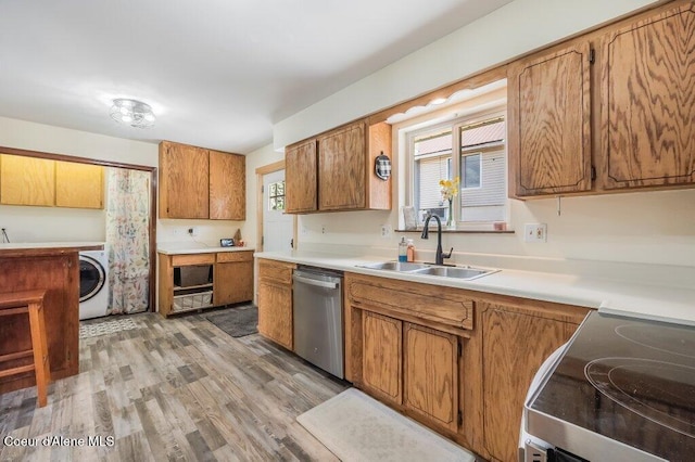 820 Plum Ln, Saint Maries, ID 83861 - kitchen featuring appliances with stainless steel finishes, a sink, brown cabinetry, washer / dryer, and light wood-type flooring